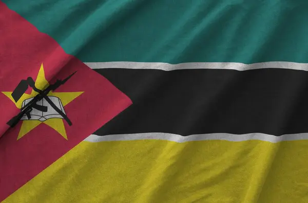stock image Mozambique flag depicted on folded wavy fabric of old cloth close up