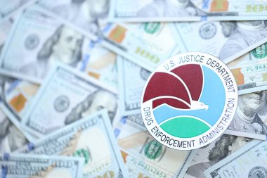 KYIV, UKRAINE - 26 Haziran 2024 ABD Adalet Bakanlığı Uyuşturucu Uygulama Dairesi Arması ABD doları banknotlarıyla yakın plan