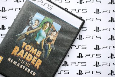 KYIV, UKRAINE - 26 Haziran 2024 Tomb Raider 1-2-3 Konsol oyunu için PS5 oyun diski kutusunda ustalaştı. Popüler video oyunu diski kapat