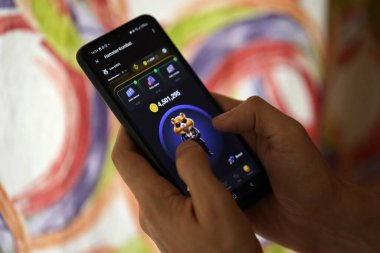 KYIV, UKRAINE - 26 Haziran 2024 Hamster Kombat mini telgraf oyunu. Akıllı telefondaki tıkırtı oyunu elinizin altında