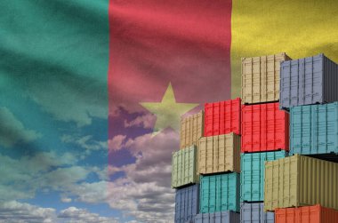 Kamerun bayrağı ve yükleme konteynırları rıhtımlarda gökyüzü arkaplanı yakın.
