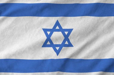 Israel flag depicted on folded wavy fabric of old cloth close up clipart