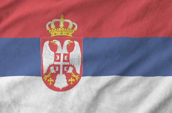 Stock image Serbia flag depicted on folded wavy fabric of old cloth close up