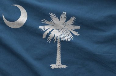 South Carolina US state flag depicted on folded wavy fabric of old cloth close up clipart