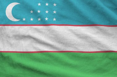 Özbekistan bayrağı eski kumaşların katlanmış dalgalı kumaşında tasvir edilmiştir.