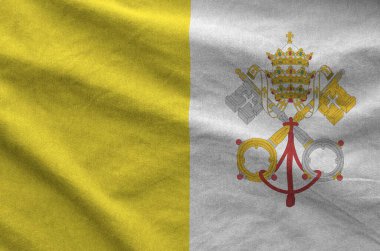 Vatikan Şehir Devleti bayrağı eski kumaştan katlanmış dalgalı kumaş üzerinde tasvir edilmiştir.