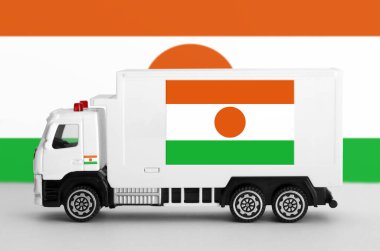 Niger flag depicted on side wall of white delivery van close up. Shipping and local delivery concept clipart