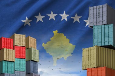 Kosova bayrağı ve rıhtımlarda gökyüzü arkaplanlı büyük kargo konteynırları yığını