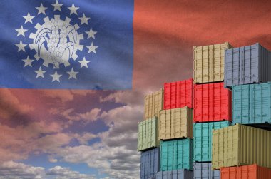 Myanmar flag and big stack of shipping cargo containers in docks with sky background close up clipart