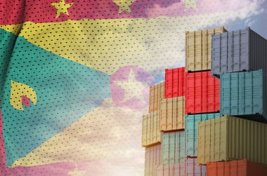 Grenada bayrağı ve yükleme konteynırları rıhtımlarda.