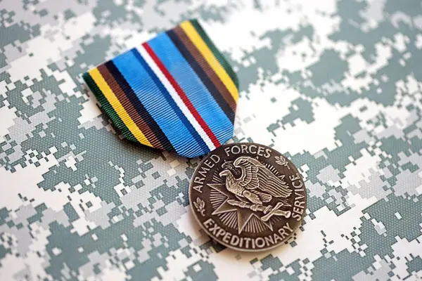 stock image KYIV, UKRAINE - JULY 10, 2024 US Armed Forces Expeditionary medal. United States military award medal with ribbon and pin. Handmade paper theater props close up