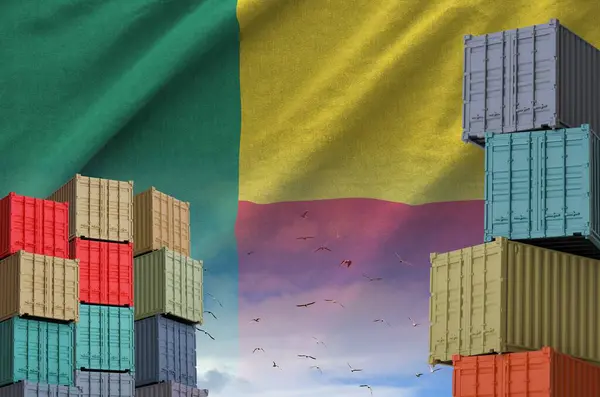 stock image Benin flag and big stack of shipping cargo containers in docks with sky background close up