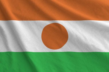 Eski kumaşın kıvrımlı kumaşında Nijer bayrağı tasvir edilmiştir.