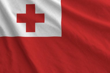 Tonga flag depicted on folded wavy fabric of old cloth close up clipart