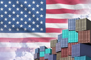 Amerika Birleşik Devletleri bayrağı ve yükleme konteynırları rıhtımlarda ve gökyüzü arka planında yakın çekim