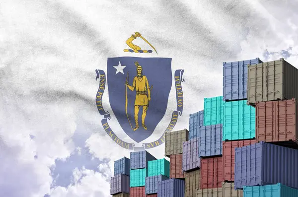 stock image Massachusetts US state flag and big stack of shipping cargo containers in docks with sky background close up