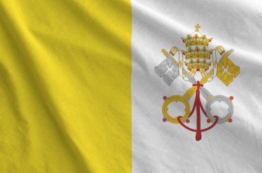 Vatikan Şehir Devleti bayrağı eski kumaştan katlanmış dalgalı kumaş üzerinde tasvir edilmiştir.