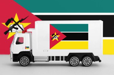 Mozambique flag depicted on side wall of white delivery van close up. Shipping and local delivery concept clipart