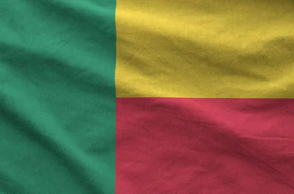 stock image Benin flag depicted on folded wavy fabric of old cloth close up