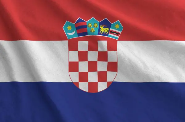 stock image Croatia flag depicted on folded wavy fabric of old cloth close up