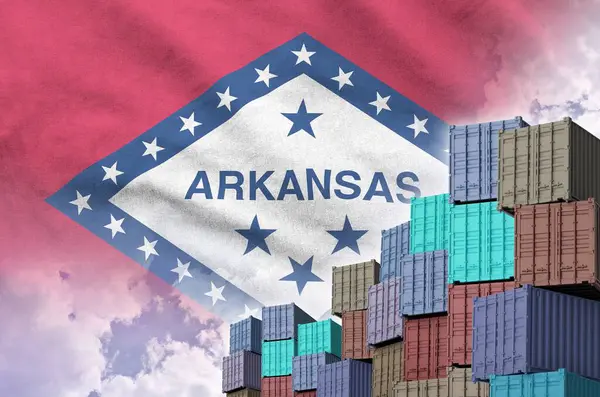 stock image Arkansas US state flag and big stack of shipping cargo containers in docks with sky background close up