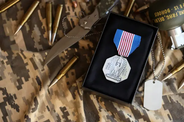 stock image KYIV, UKRAINE - JULY 10, 2024 US Non-Combat Heroism Soldiers medal. United States military award medal with ribbon and pin. Handmade paper theater props close up