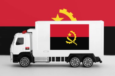 Angola flag depicted on side wall of white delivery van close up. Shipping and local delivery concept clipart