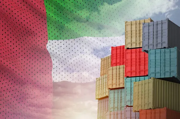 stock image United Arab Emirates flag and big stack of shipping cargo containers in docks with sky background close up