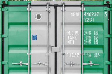 Nigeria flag depicted on metal doors of shipping cargo container outdoors in docks area close up clipart