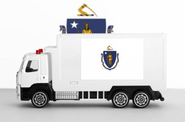 Massachusetts US state flag depicted on side wall of white delivery van close up. Shipping and local delivery concept clipart