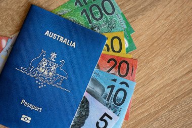 KYIV, UKRAINE - 10 Temmuz 2024 Avustralya mavi seyahat pasaportu ve ahşap arka planda para yakın plan