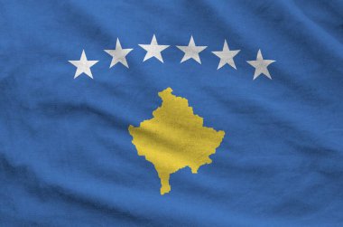 Kosovo flag depicted on folded wavy fabric of old cloth close up clipart