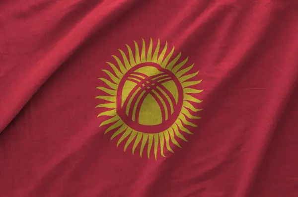 stock image Kyrgyzstan flag depicted on folded wavy fabric of old cloth close up