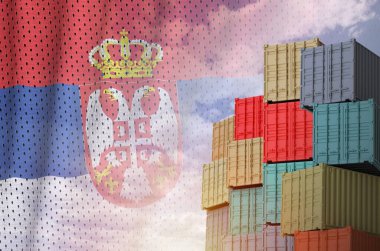 Serbia flag and big stack of shipping cargo containers in docks with sky background close up clipart