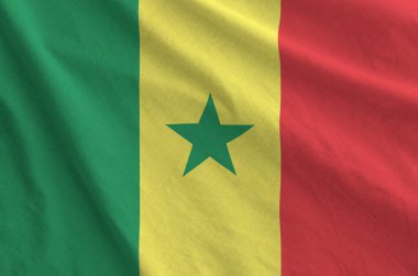 Senegal flag depicted on folded wavy fabric of old cloth close up clipart