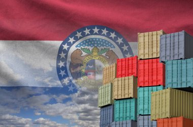 Missouri US state flag and big stack of shipping cargo containers in docks with sky background close up clipart