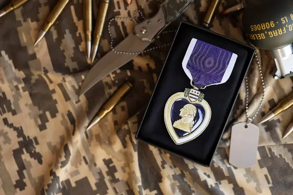 stock image KYIV, UKRAINE - JULY 10, 2024 US Purple Heart medal. United States military award medal with ribbon and pin. Handmade paper theater props close up