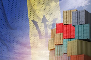 Barbados flag and big stack of shipping cargo containers in docks with sky background close up clipart