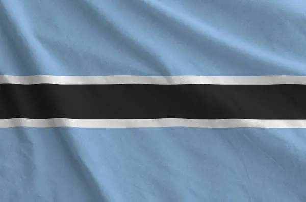 stock image Botswana flag depicted on folded wavy fabric of old cloth close up