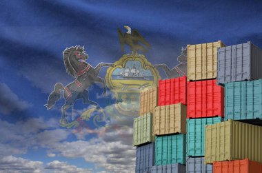 Pennsylvania US state flag and big stack of shipping cargo containers in docks with sky background close up clipart