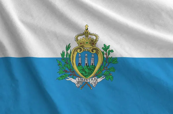 stock image San Marino flag depicted on folded wavy fabric of old cloth close up