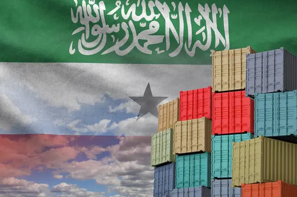 stock image Somaliland flag and big stack of shipping cargo containers in docks with sky background close up