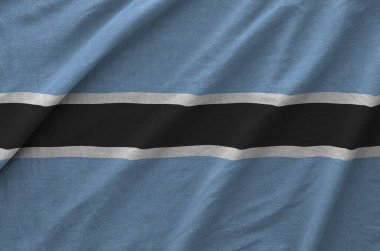 Botswana flag depicted on folded wavy fabric of old cloth close up clipart