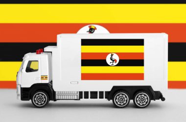 Beyaz minibüsün yan duvarında Uganda bayrağı tasvir edilmiş. Nakliye ve yerel teslimat kavramı
