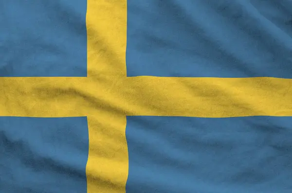 stock image Sweden flag depicted on folded wavy fabric of old cloth close up