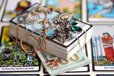 KYIV, UKRAINE - 10 Temmuz 2024 Tarot minör ve Rider Waite esrarengiz güverte ve altın yüzükler ve kolye zincirleri büyük arkana kartları. Falcılık için birçok tarot kartı ve pahalı eşyalar kapatılıyor