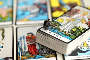 KYIV, UKRAINE - 10 Temmuz 2024 Tarot minör ve Rider Waite esrarengiz güverte büyük arcana kartları ve siyah elmas mücevherli gümüş yüzük. Falcılık ve cadı halkası için bir sürü tarot kartı.