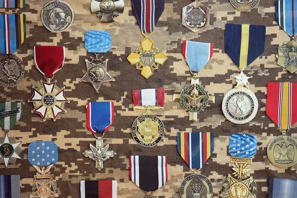 stock image KYIV, UKRAINE - JULY 10, 2024 Many US military achievement medals on camouflage background. United States award medals. Handmade paper theater props close up