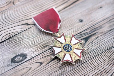 KYIV, UKRAINE - 10 Temmuz 2024 ABD Liyakat Madalyası. Birleşik Devletler askeri madalyası, kurdele ve broşla. El yapımı kağıt tiyatro dekorları yakın plan.