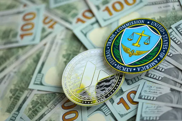 stock image KYIV, UKRAINE - AUGUST 17, 2024 Avalanche AVAX coin and US Federal Trade Commission sign on many USD dollar money bills close up